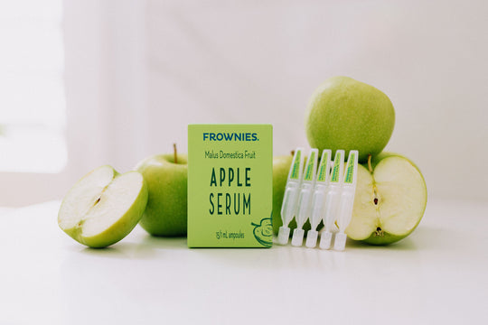 apple serum sitting next to green apples on a counter