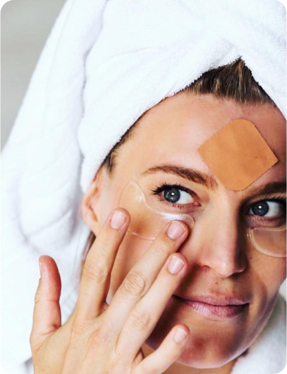 woman wearing frownies wrinkle patches applying cactus collagen eye gels