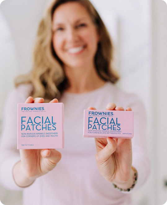 woman holding two pink boxes of frownies wrinkle patches for forehead and between the eyes and for crows feet and smile lines