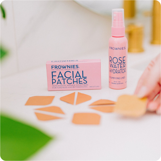 frownies facial patches with pink box and rose water spray bottle sitting on a bathroom counter