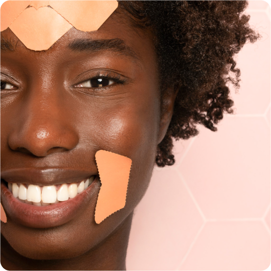 zoomed in picture of woman on peach background wearing facial patches on her forehead and smile lines