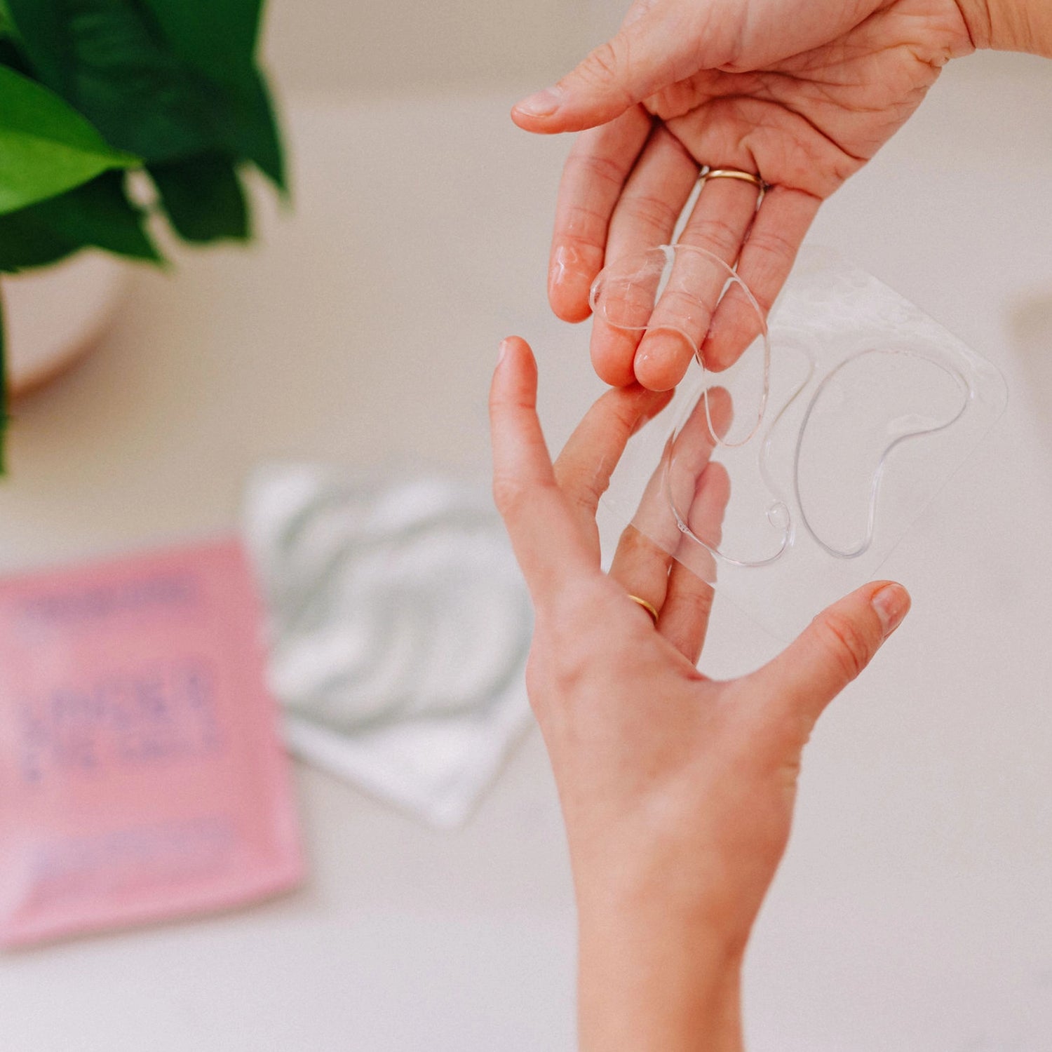 Frownies under eye gels being taken out of the packaging, showcasing their appearance and texture.