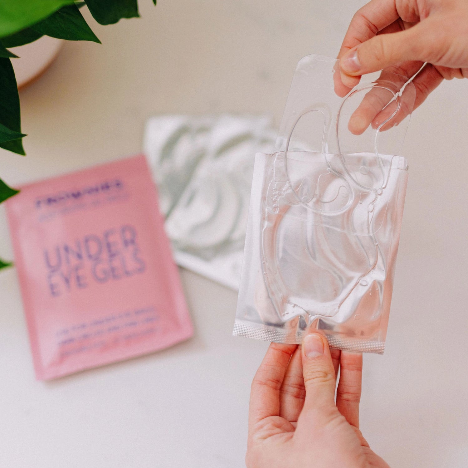 Frownies under eye gels being taken out of the packaging, showcasing their appearance and texture.