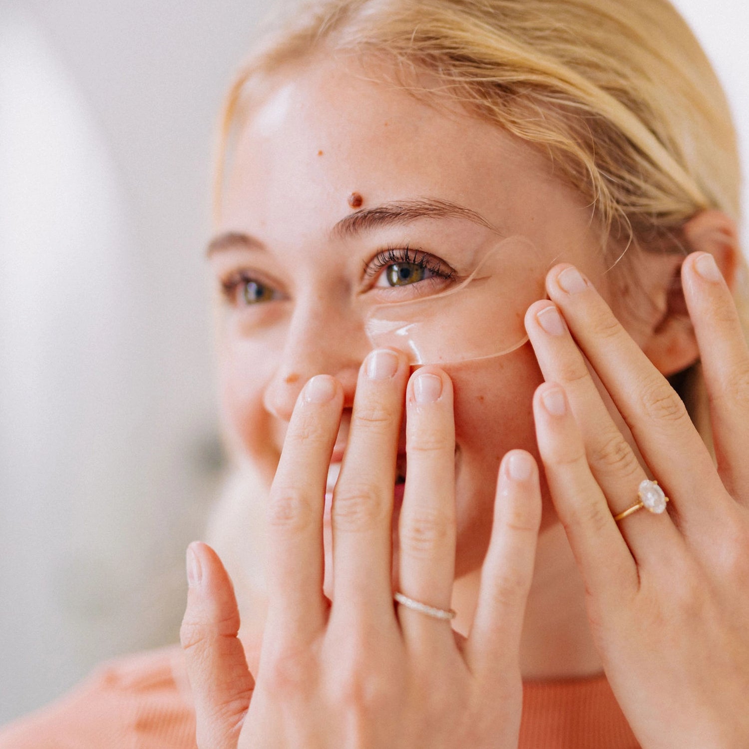 Frownies under eye gels being applied beneath the eye, showing how they look once placed on the skin.