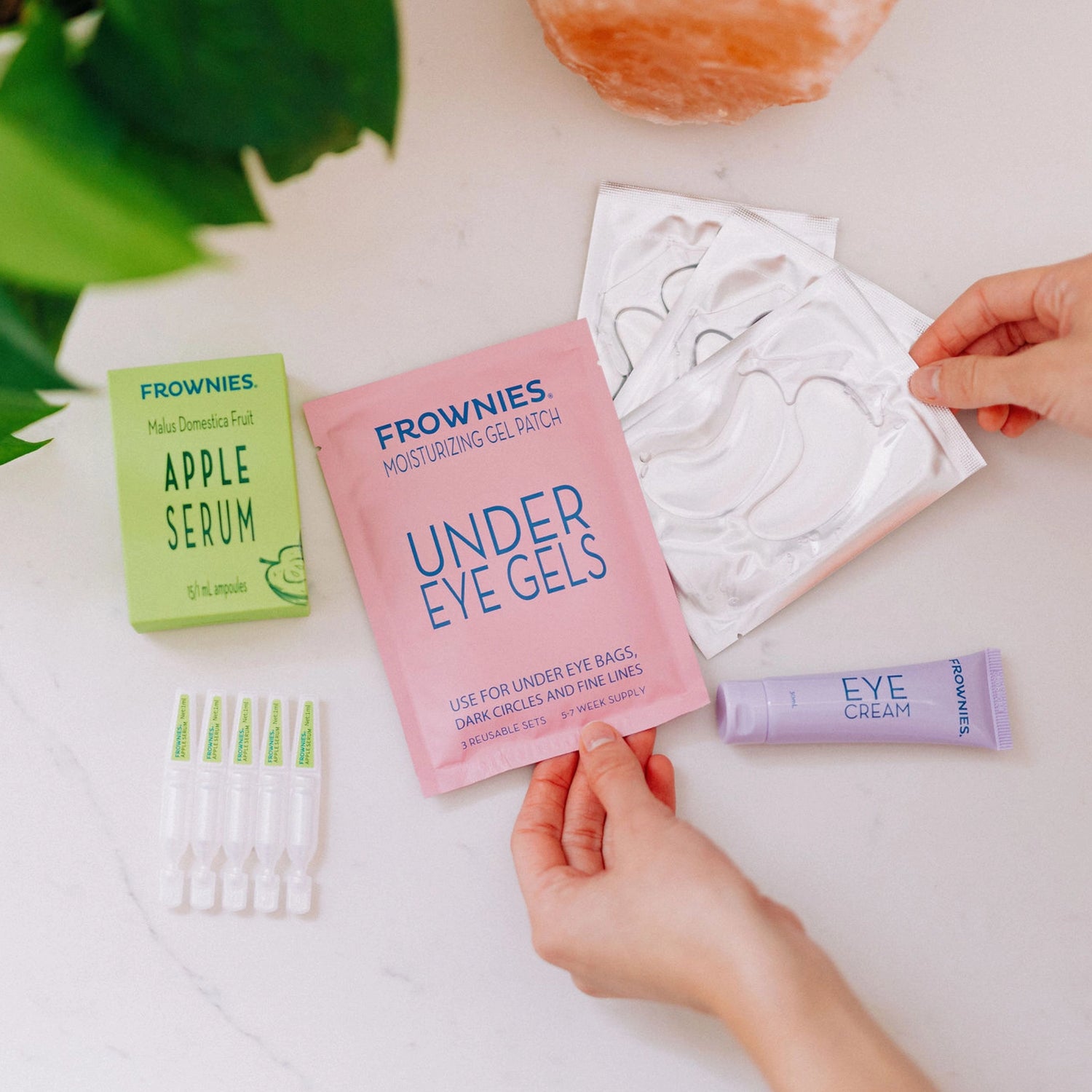 Frownies under eye gels displayed alongside apple serum and eye cream.