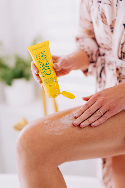 woman apply cellulite firming cream to her thigh 
