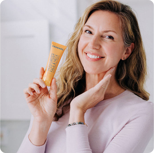 woman holding bottle of gel face moisturizer and touching cheek