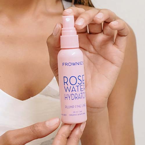 hands holding pink bottle of Rose Water Hydrator Spray (2 oz) Facial Patches Frownies   
