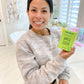 woman holding green box of Apple Serum-Malus Domestica-Apple Stem Cell Extract Skincare Products The Frownies   