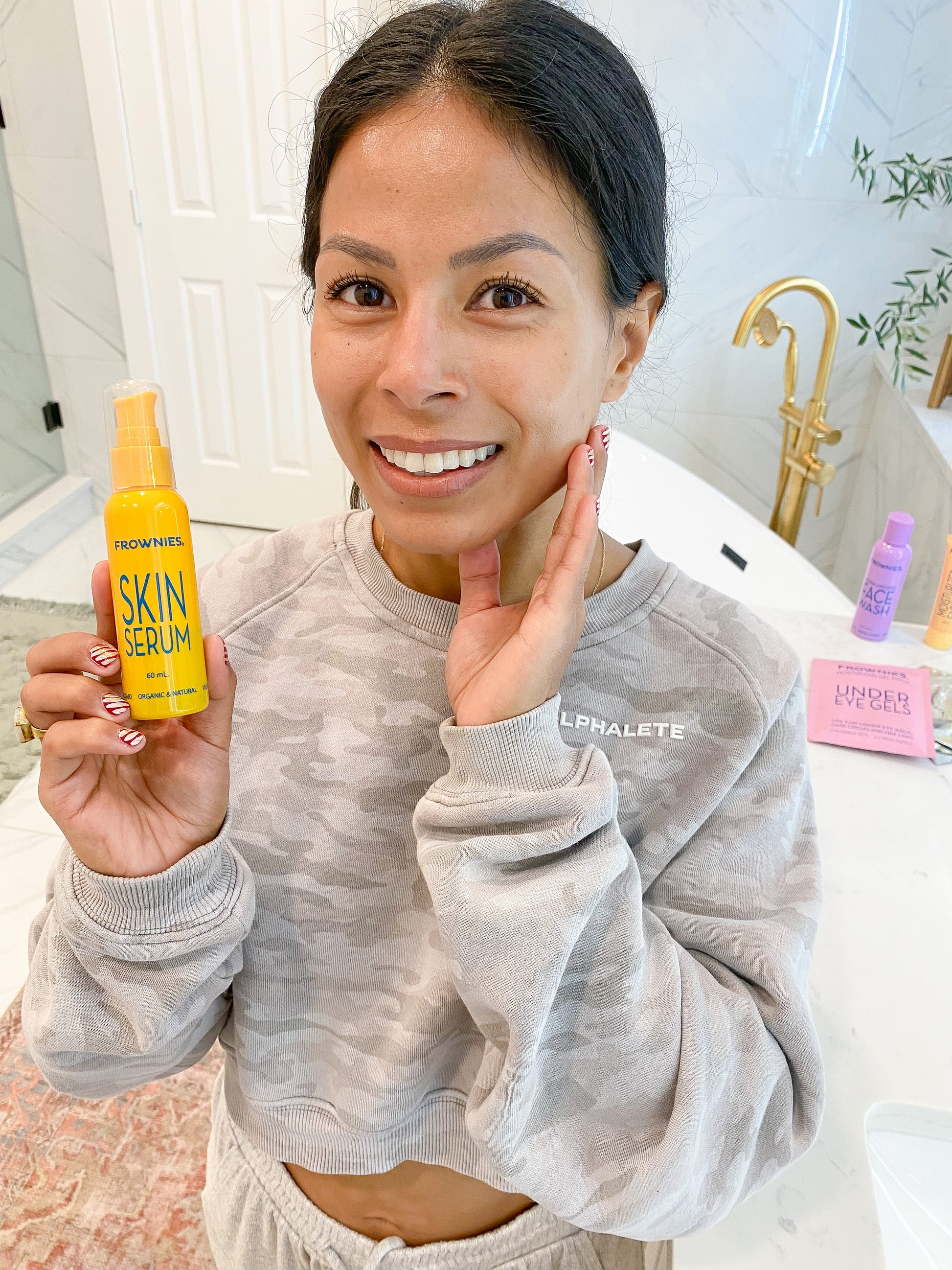 woman touching face holding yellow bottle of Vitamin C & E Skin Serum (2 oz) Skincare Products Frownies   