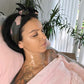 woman in pink towel wearing Neck Mask with Apple Stem Cell Serum Facial Patches, The Frownies   