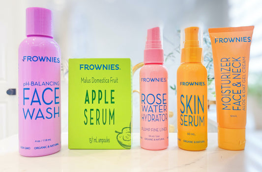 five of Frownies skincare products in a row on a bathroom countertop