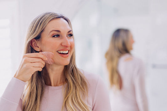 Woman using gua sha stone on her jaw line