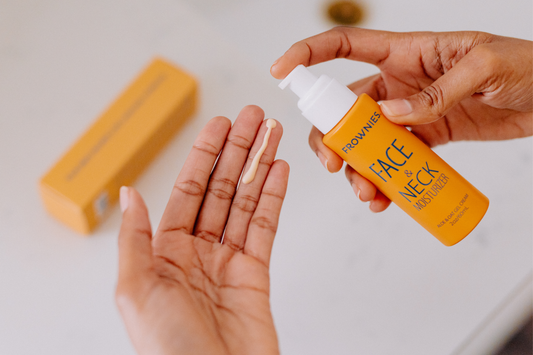 Person pumped Frownies Face & Neck Moisturizer onto a finger tip for application