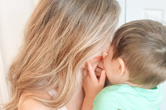 close up of mother hugging small child