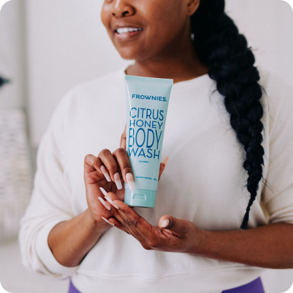 woman holding a new bottle of citrus honey body wash