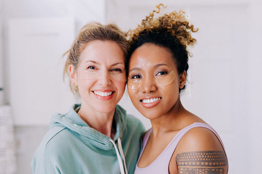 two smiling women wearing frownies reusable under eye gels to brighten dark circles