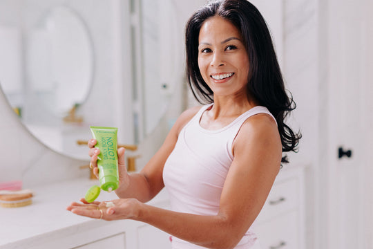 woman squeezing body lotion with essential oils in to her hand
