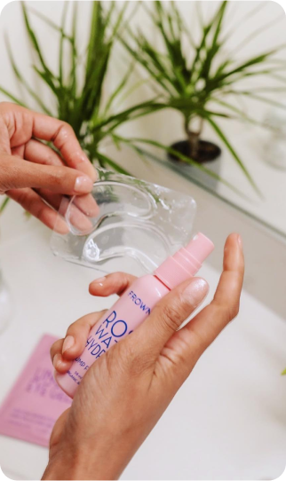 woman's hands spraying rose water on frownies under eye gels in packaging