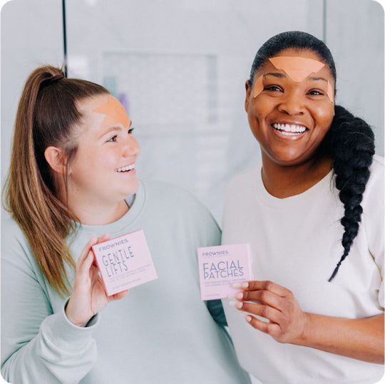 Two women with pink boxes of frownies facial patches and gentle lifts skin care products