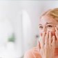blonde woman applying frownies under eye gels with cactus collagen on face