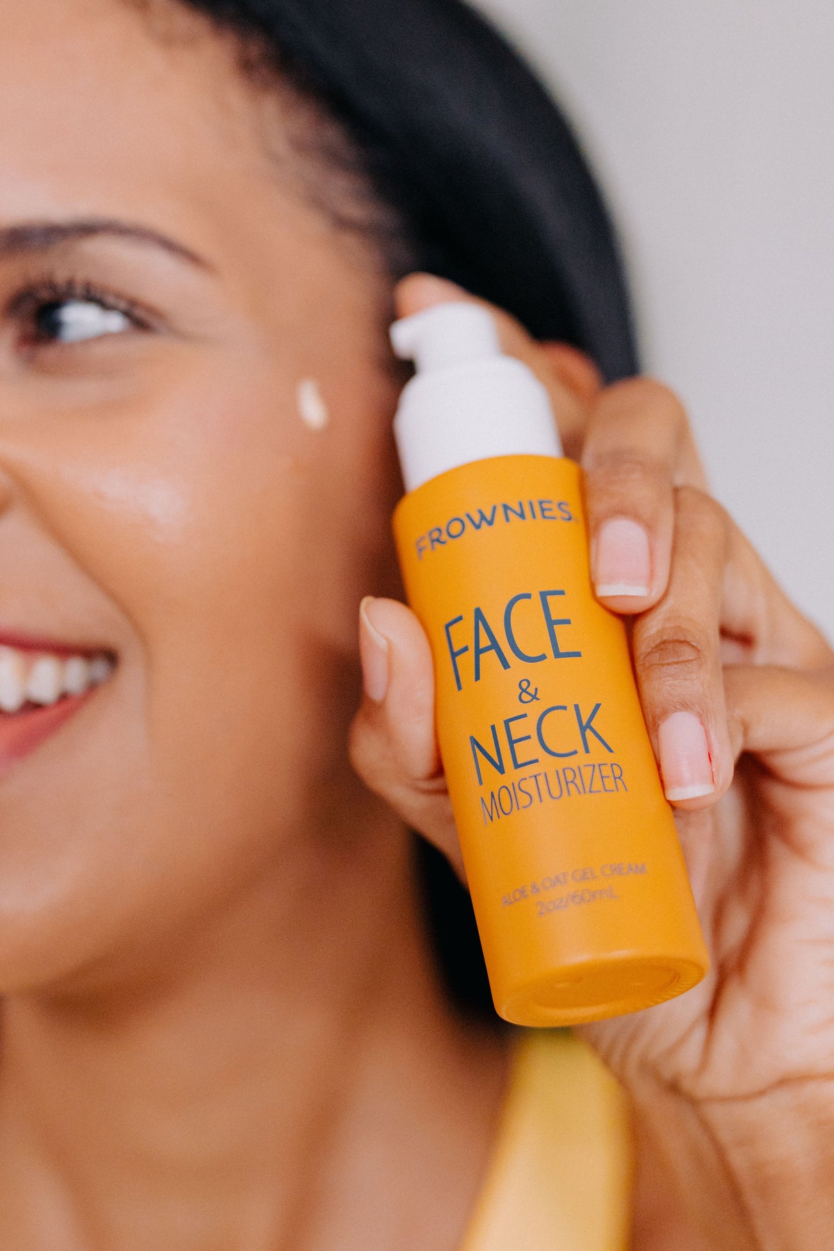 Woman applying Frownies Face and Neck Moisturizer