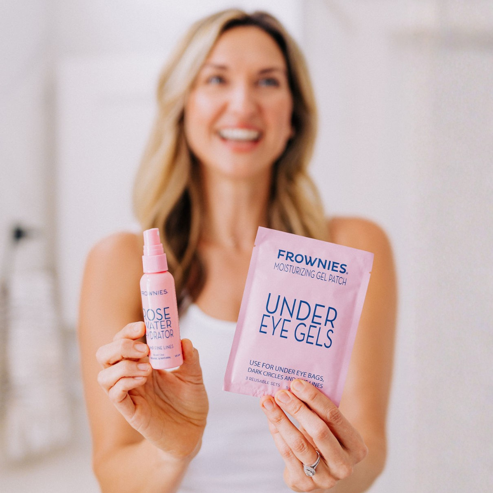 Woman smiling in the background holding a Rose Water Hydrator Spray and Frownies Under Eye gels