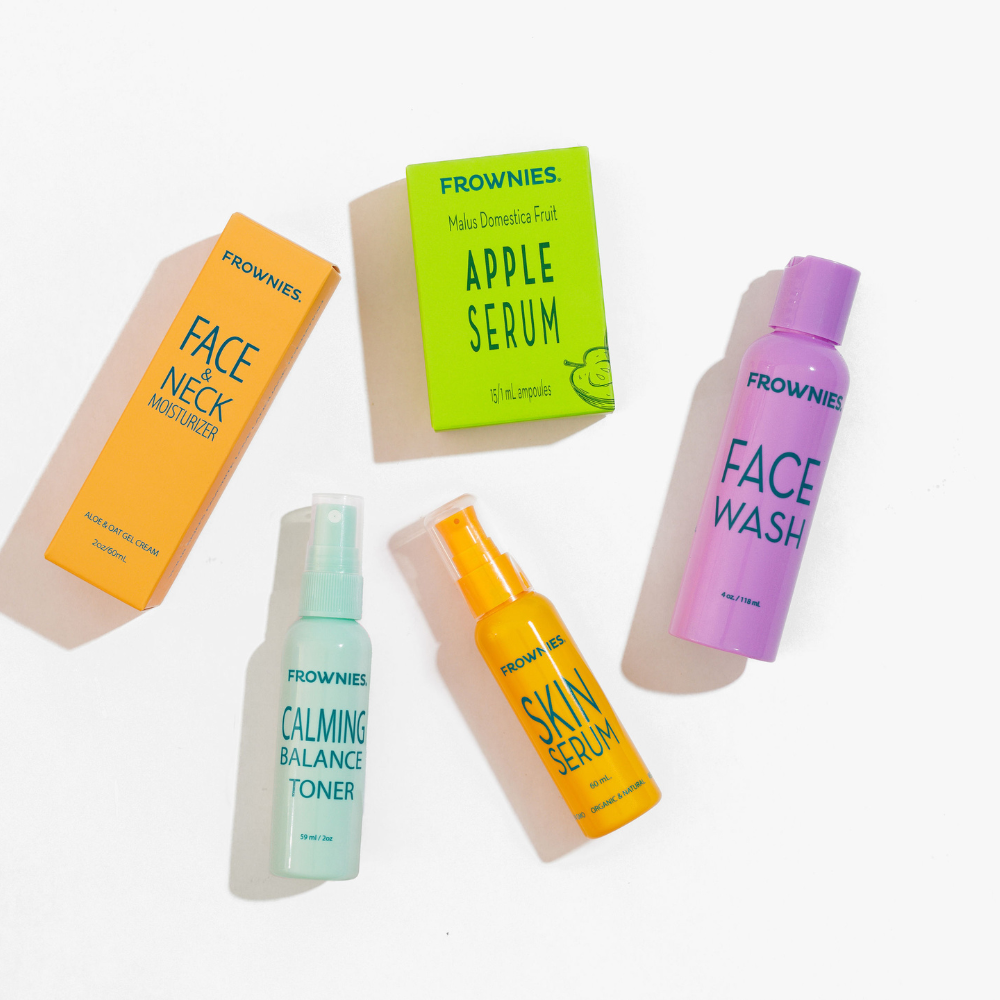 Frownies skincare products including Face & Neck Moisturizer, Apple Serum, Calming Balance Toner, Skin Serum, and Face Wash on a white background.