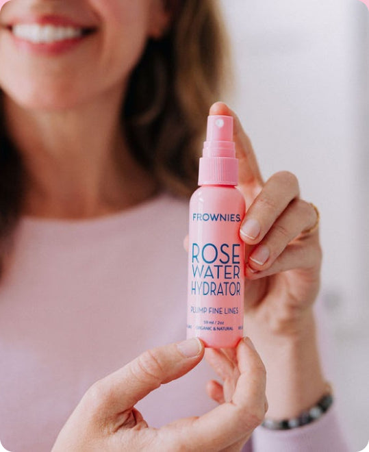 woman's hands holding pink bottle of rose water facial toner with hyaluronic acid