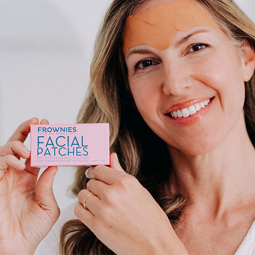 woman holding box of Frownies facial Patches