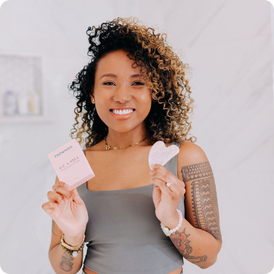 woman holding up Frownies gua sha