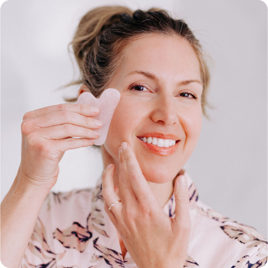 woman using rose quartz gua sha