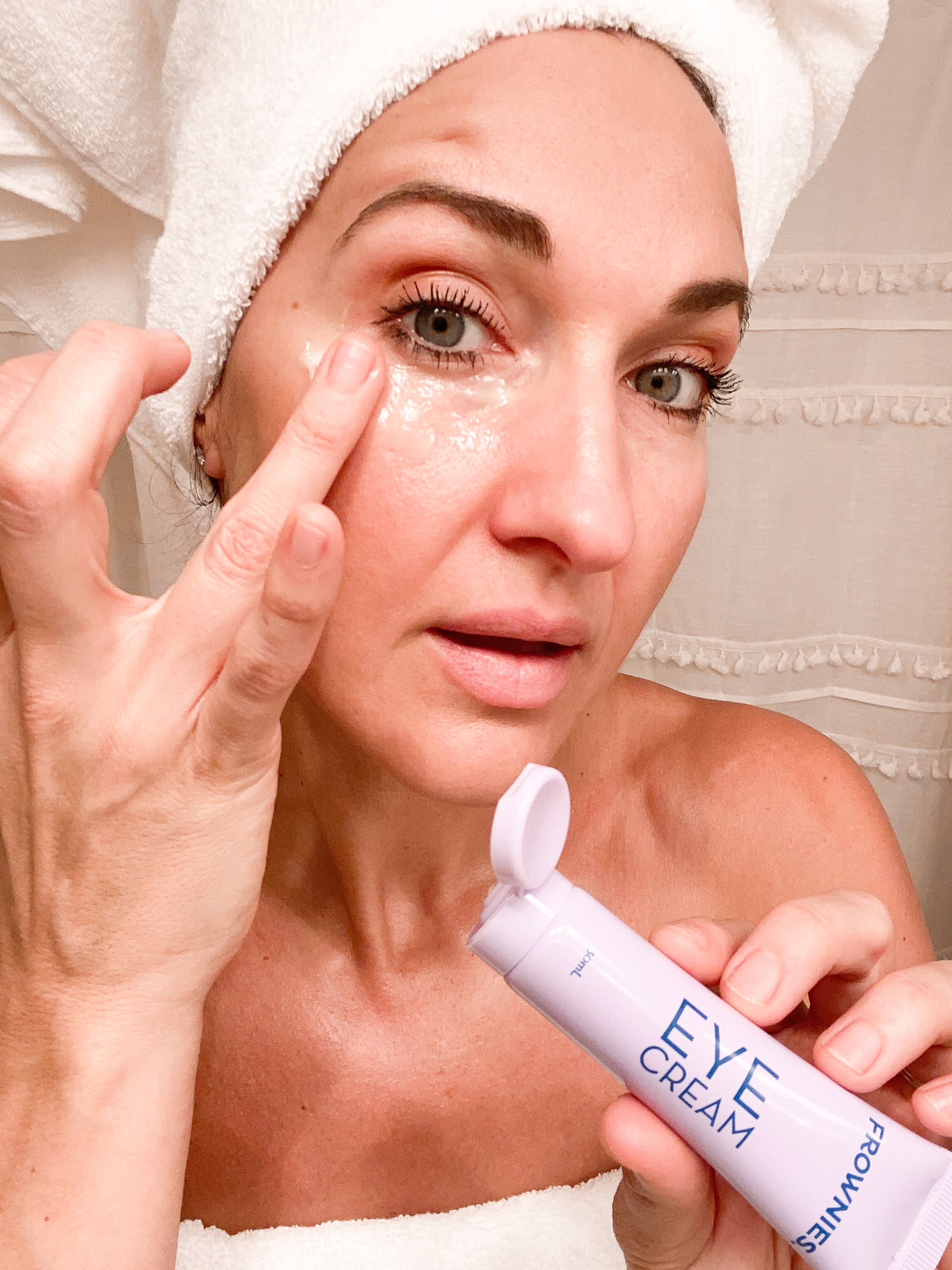 woman in white towel applying Vitamin E Eye Cream Skincare Products Frownies   
